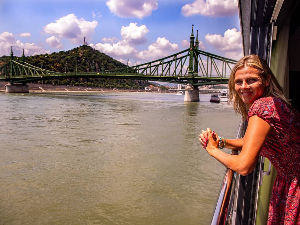 Ladt looking out the window of a cruise ship towards a bridge