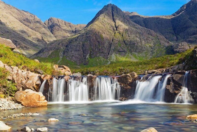 A large waterfall in front of a mountain