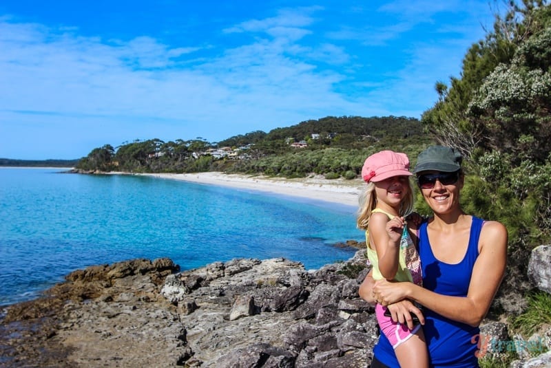 woman and child posing to camera in front of beach view