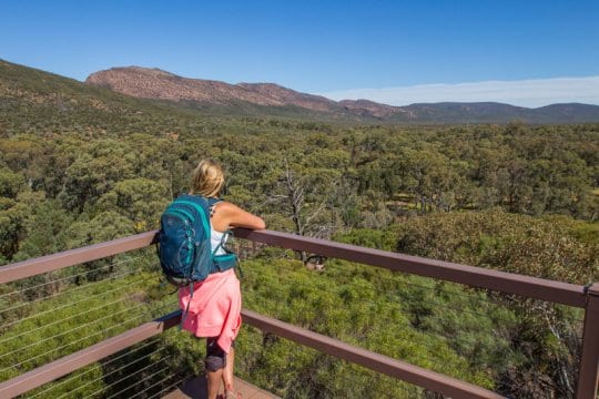 woman standing on a balcony looking at mountains